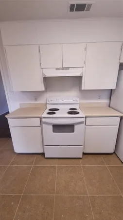 a close view of washer and dryer with kitchen in the background