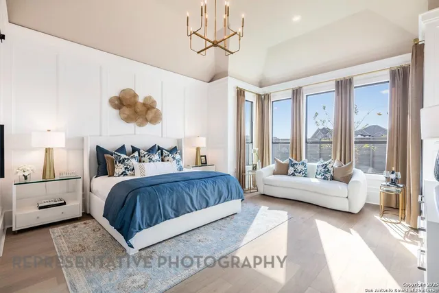 a spacious bedroom with a bed a couch and a chandelier