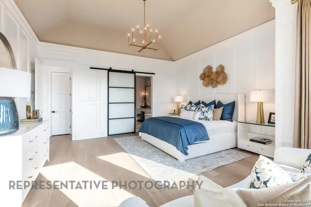 a bedroom with a large bed and a chandelier
