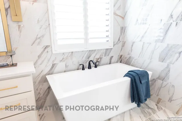 a white bath tub sitting next to a white sink