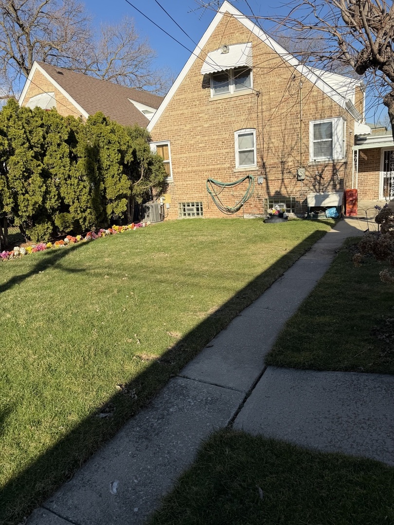 10210 South Rhodes Avenue Chicago, IL 60628 - Photo 12 of 12 a front view of a house with a yard
