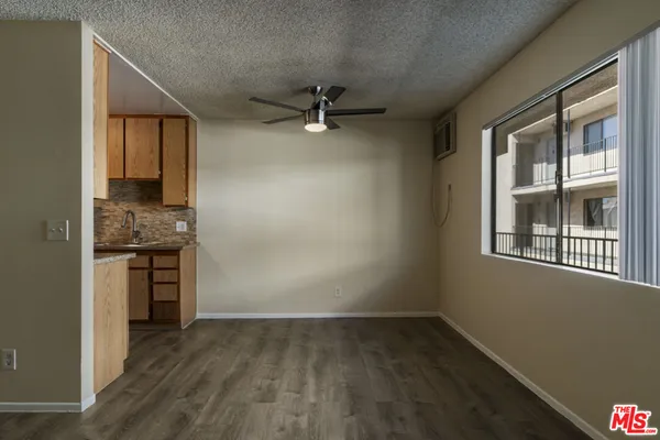 an empty room with a kitchen and a window