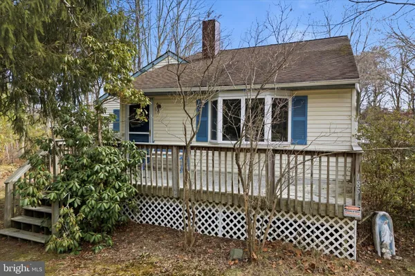 a view of a house with a small yard and wooden fence
