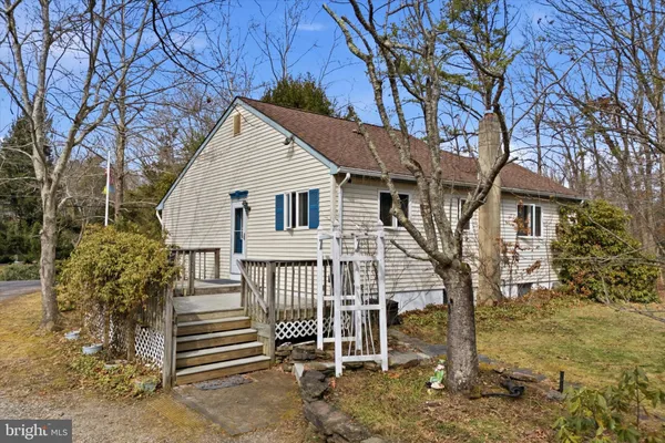 a view of a house with a small yard and large tree