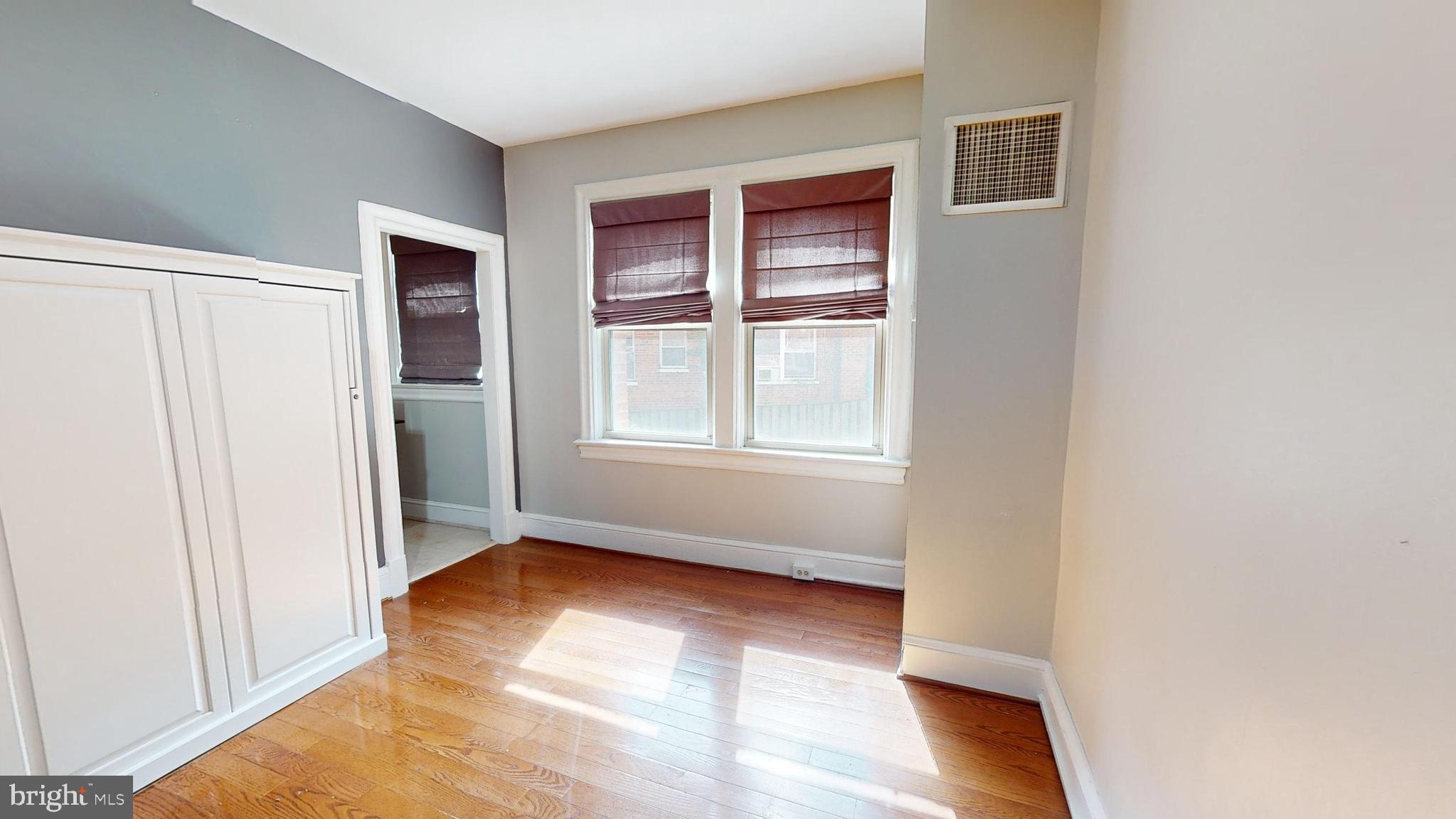 3446 Connecticut Avenue Northwest, Unit 203 Washington, DC 20008 - Photo 9 of 11 an empty room with wooden floor and windows