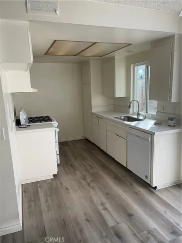 a room with a sink a stove and cabinets