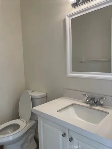 a bathroom with a toilet a sink and mirror