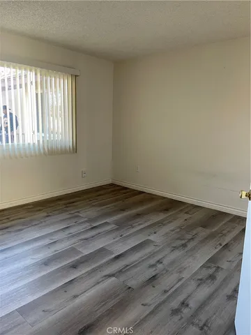 a view of a room that has wooden floor and window