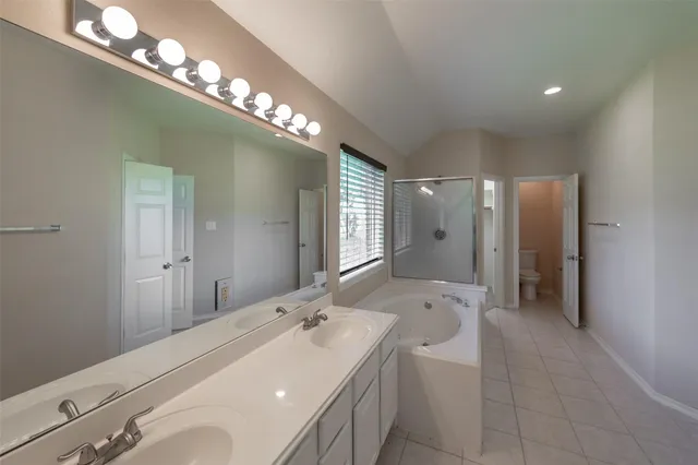 a spacious bathroom with a double vanity sink toilet mirror and bathtub