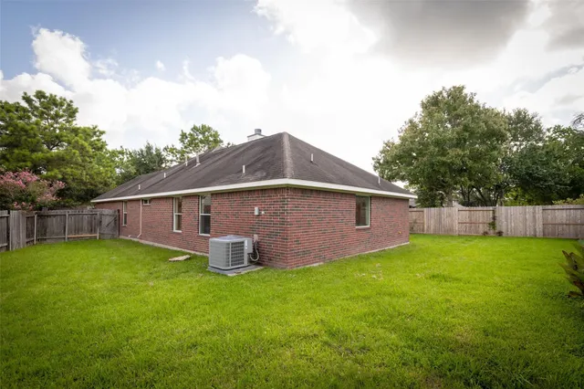 a house that is sitting in the grass with tress in the background