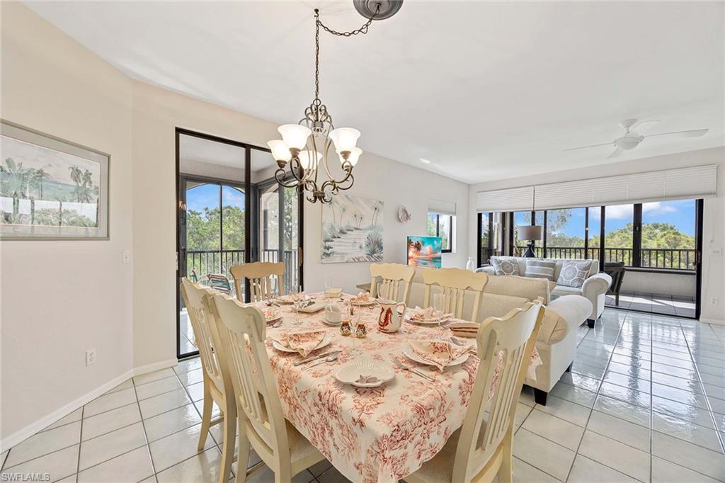 6500 Valen Way, Unit A402 Naples, FL 34108 - Photo 16 of 49 a view of a dining room with furniture wooden floor and chandelier