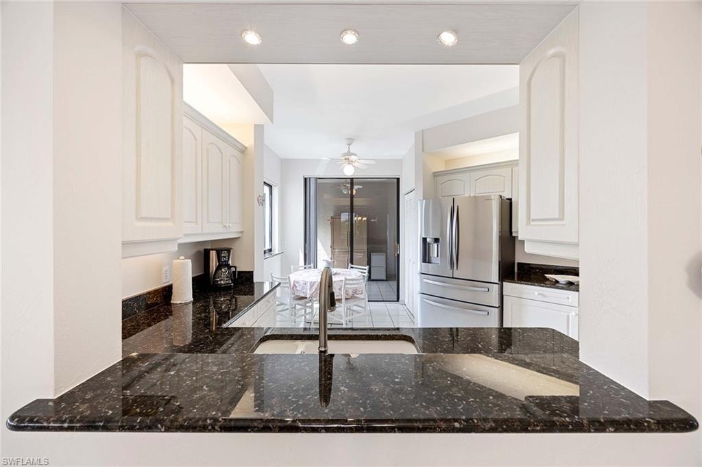 6500 Valen Way, Unit A402 Naples, FL 34108 - Photo 17 of 49 a kitchen with stainless steel appliances granite countertop a sink refrigerator and cabinets