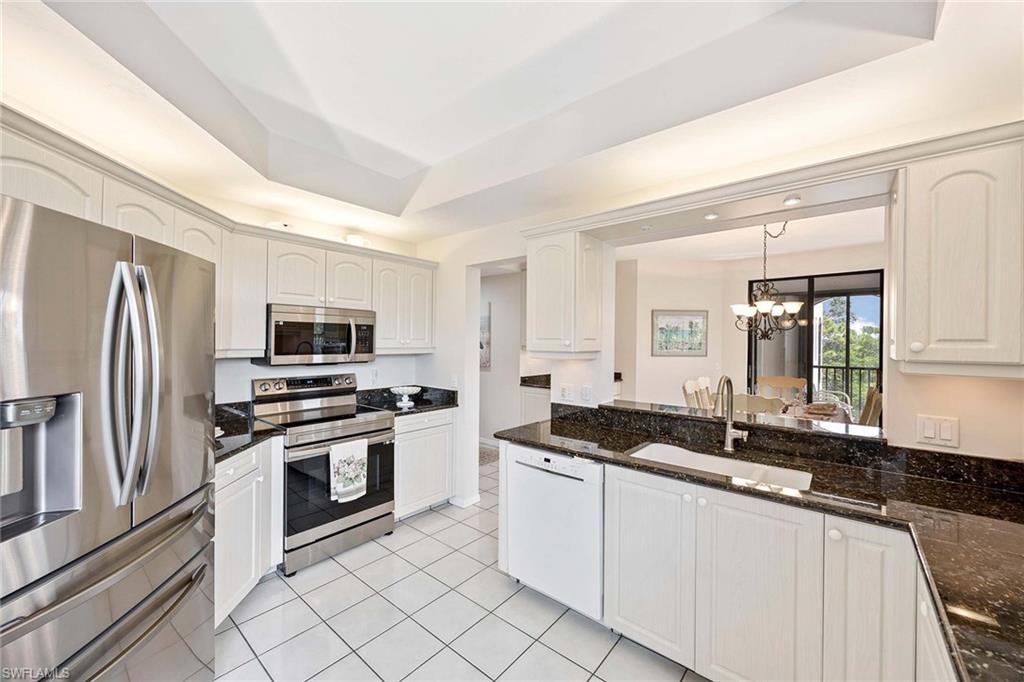 6500 Valen Way, Unit A402 Naples, FL 34108 - Photo 18 of 49 a kitchen with stainless steel appliances granite countertop a sink and stove top oven