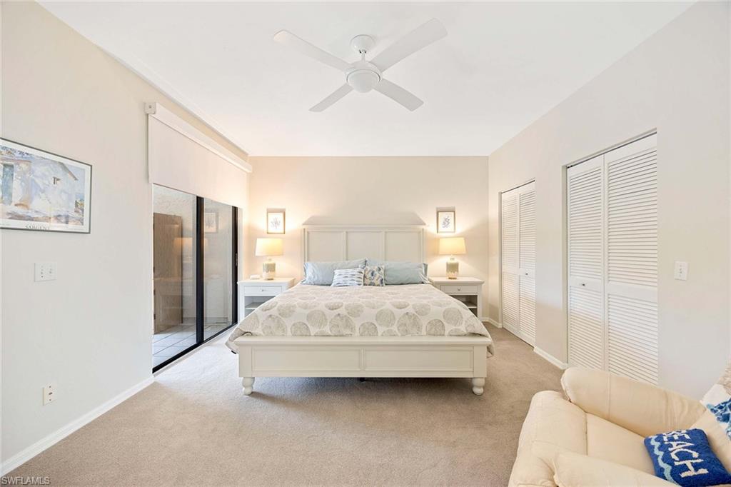 6500 Valen Way, Unit A402 Naples, FL 34108 - Photo 22 of 49 a bedroom with a bed and a chandelier