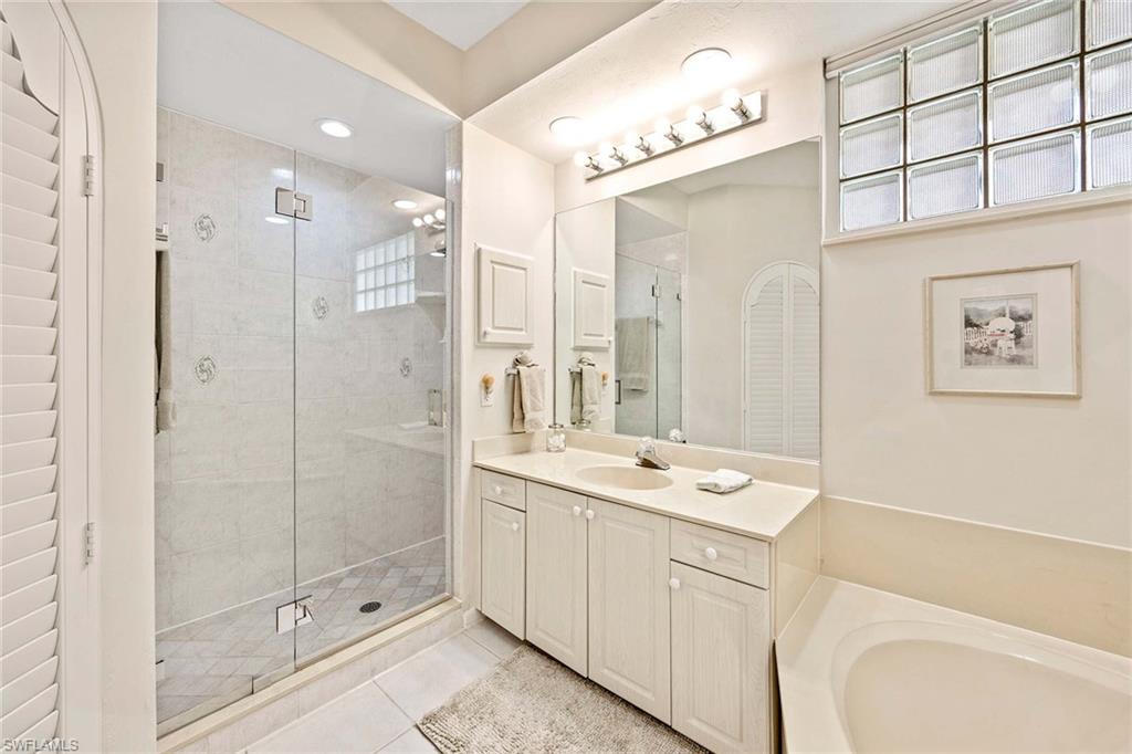 6500 Valen Way, Unit A402 Naples, FL 34108 - Photo 25 of 49 a bathroom with a shower sink and mirror