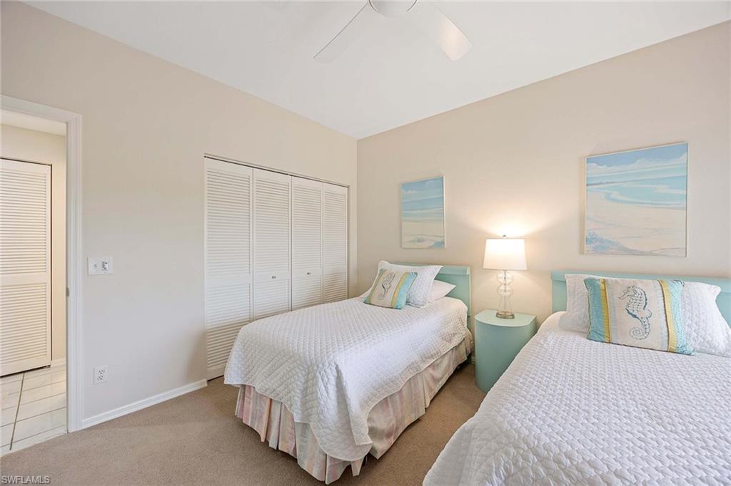 6500 Valen Way, Unit A402 Naples, FL 34108 - Photo 29 of 49 a bedroom with a bed and night stand