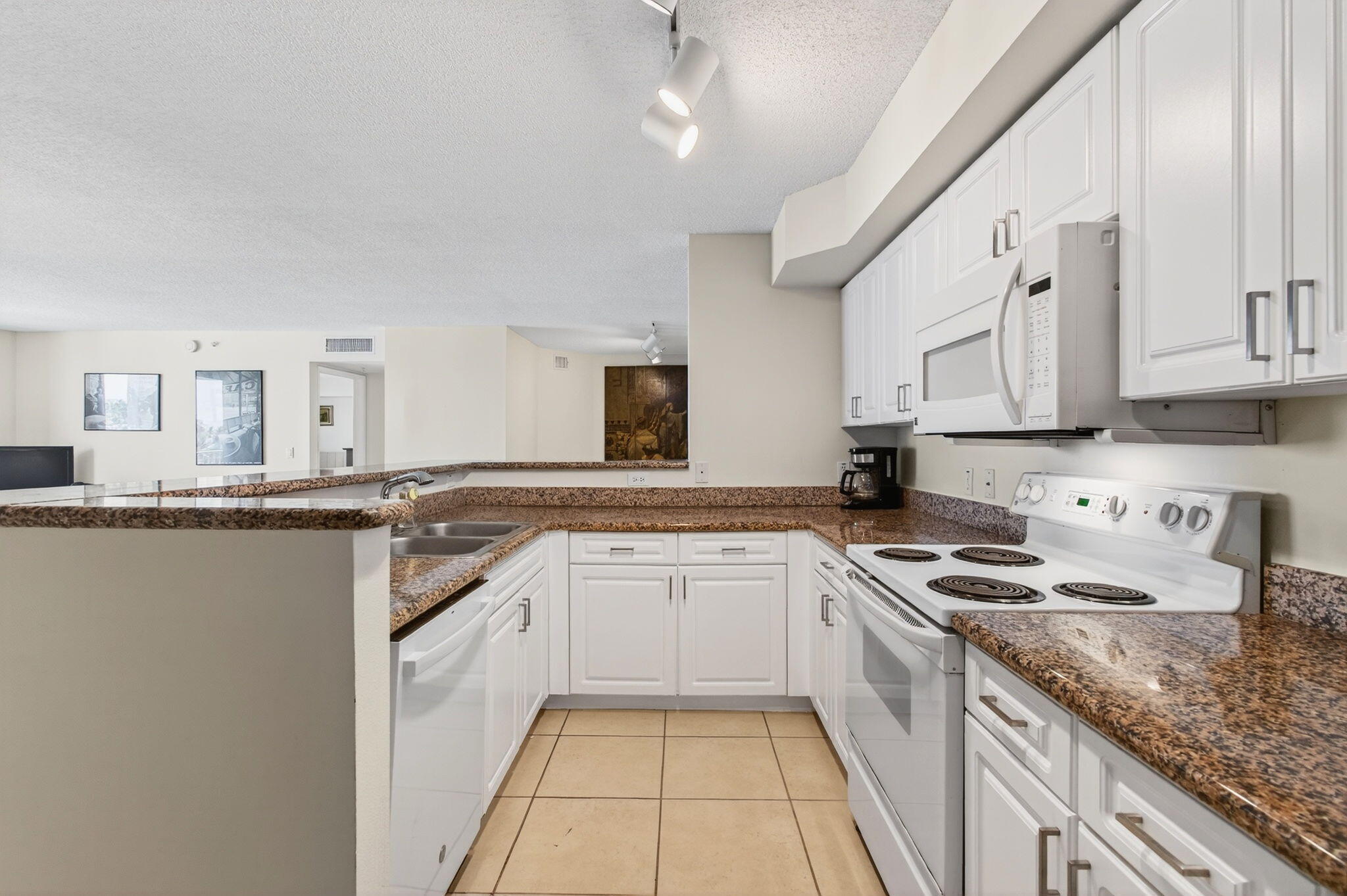 3606 South Ocean Boulevard, Unit 406 Highland Beach, FL 33487 - Photo 22 of 30 a kitchen with granite countertop a sink stove and cabinets