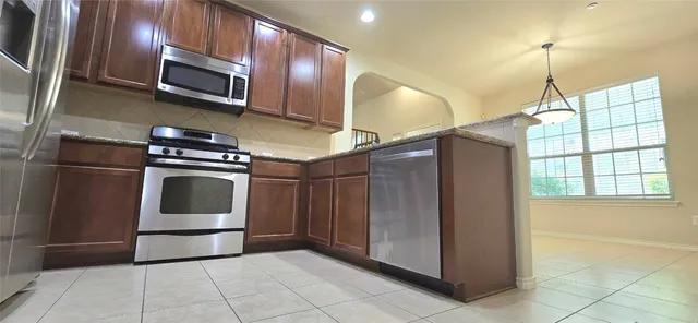a kitchen with stainless steel appliances granite countertop a refrigerator and a microwave