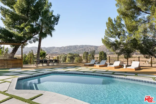 a view of swimming pool with outdoor seating and trees