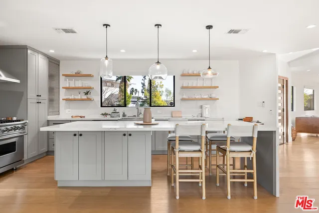 a kitchen with appliances a sink and chairs