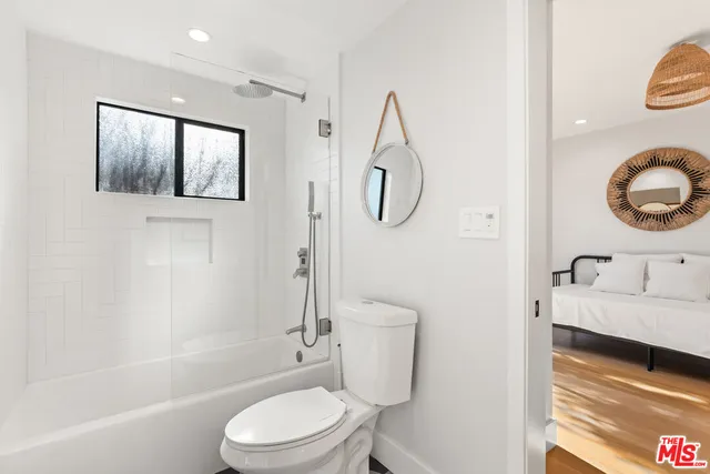 a bathroom with a granite countertop toilet sink and mirror
