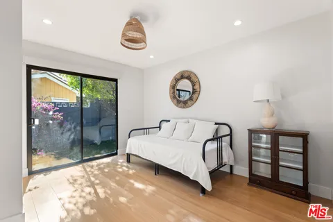 a spacious bedroom with a bed a mirror and a window