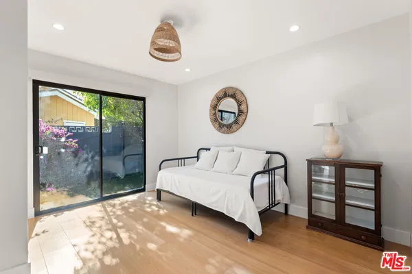 a spacious bedroom with a bed a mirror and a window
