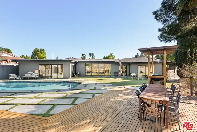 a view of a house with backyard and sitting area