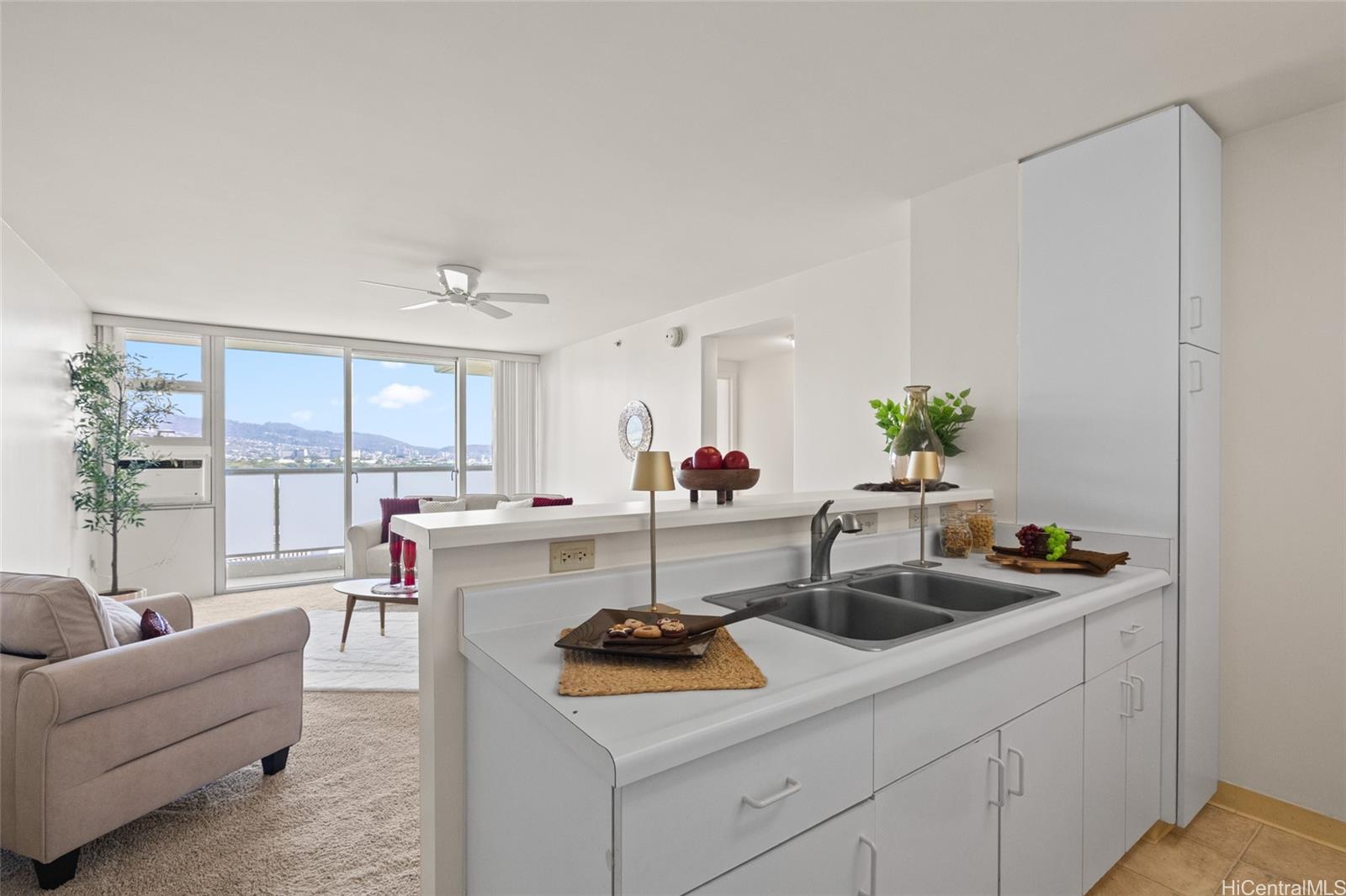 3009 Ala Makahala Place, Unit 1804 Honolulu, HI 96818 - Photo 4 of 20 a kitchen with a sink and white cabinets