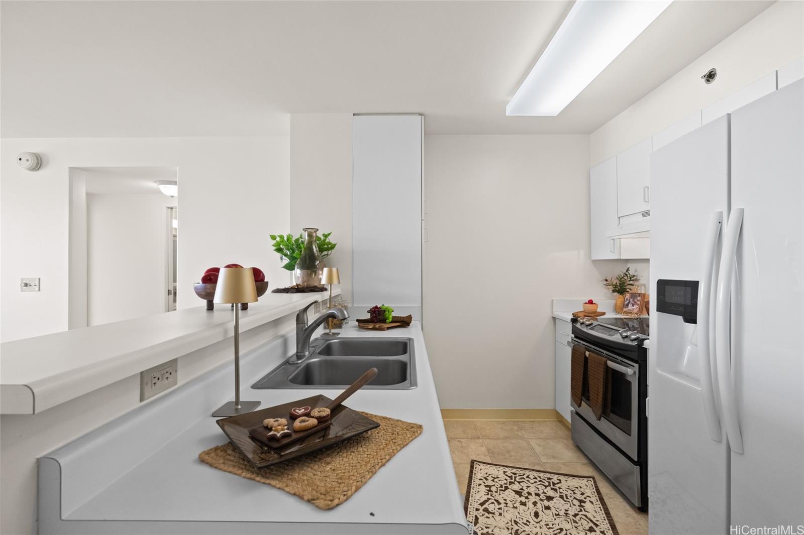 3009 Ala Makahala Place, Unit 1804 Honolulu, HI 96818 - Photo 7 of 20 a kitchen with a sink stove and refrigerator