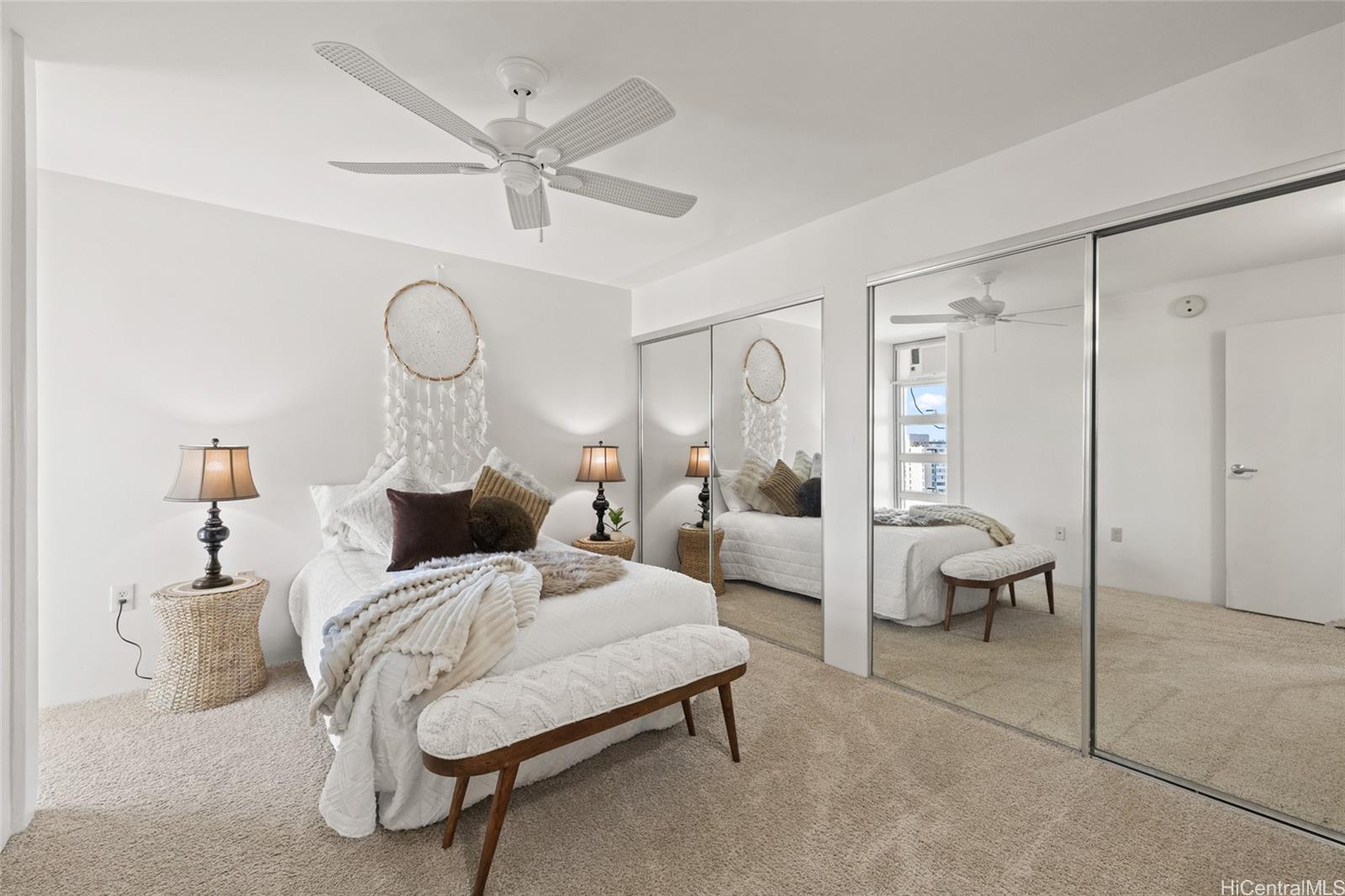 3009 Ala Makahala Place, Unit 1804 Honolulu, HI 96818 - Photo 8 of 20 a bed room with a bed and a chandelier