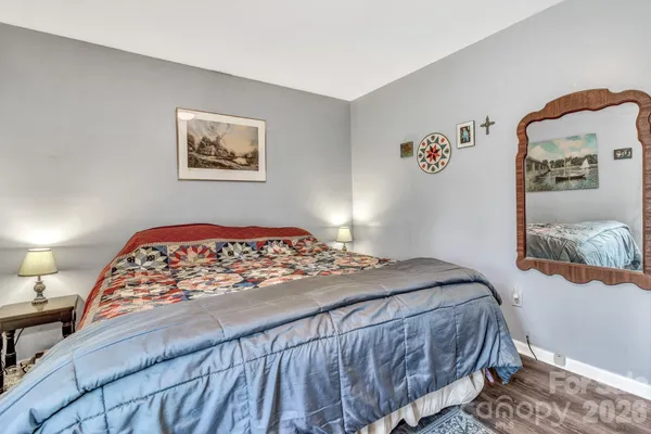 a bedroom with a bed and a painting on the wall