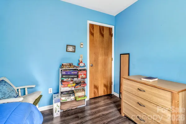 a view of a bedroom with wooden floor