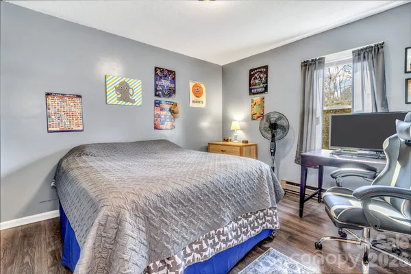 a bedroom with a bed and wooden floor