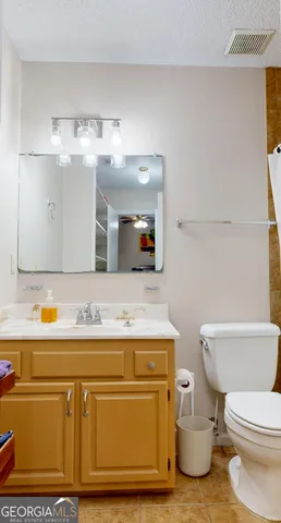 a bathroom with a sink a toilet and mirror