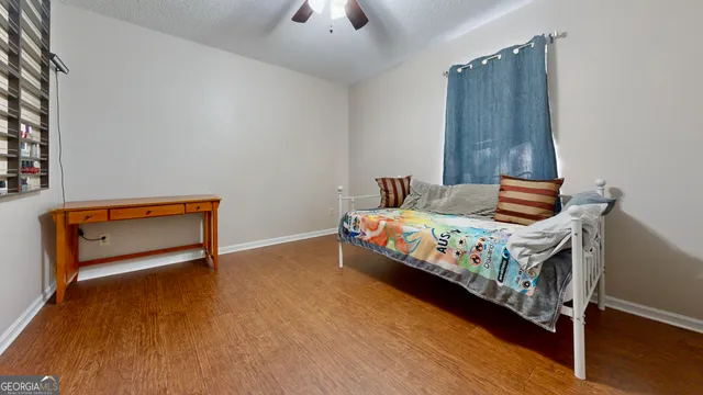 a bedroom with a bed and a ceiling fan