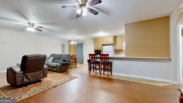 a living room with furniture and a ceiling fan