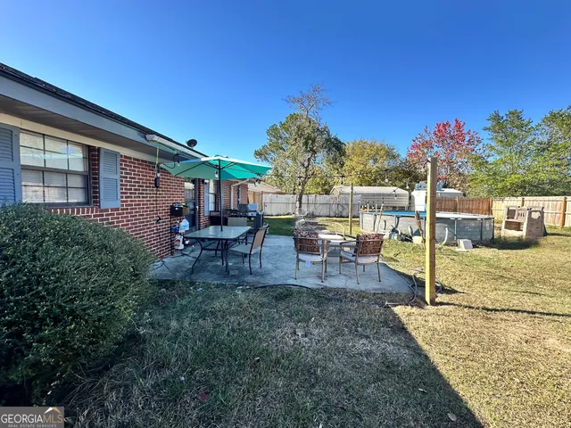 a view of a house with backyard and sitting area