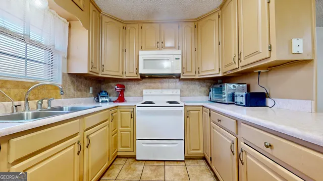 a kitchen with stainless steel appliances granite countertop a sink a stove and cabinets