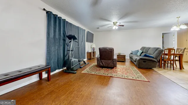 a living room with furniture gym equipment and a flat screen tv