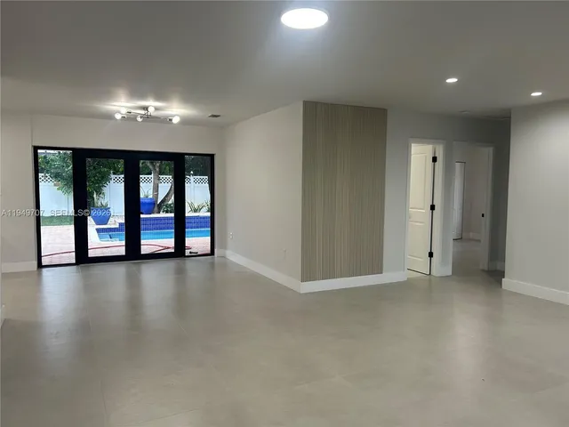an empty room with floor to ceiling windows and pool table