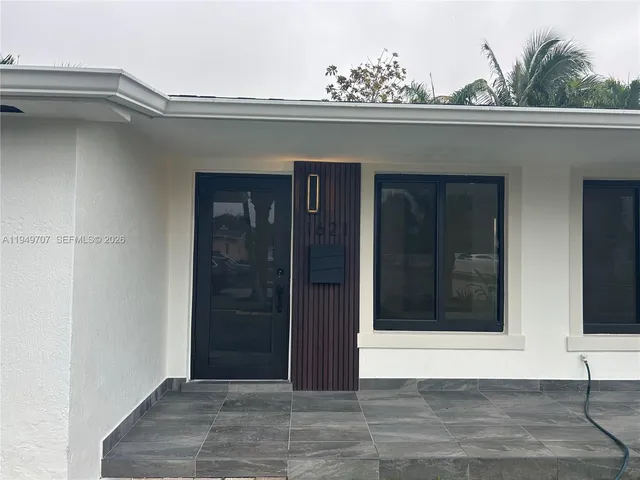 a front view of a house with garden and patio