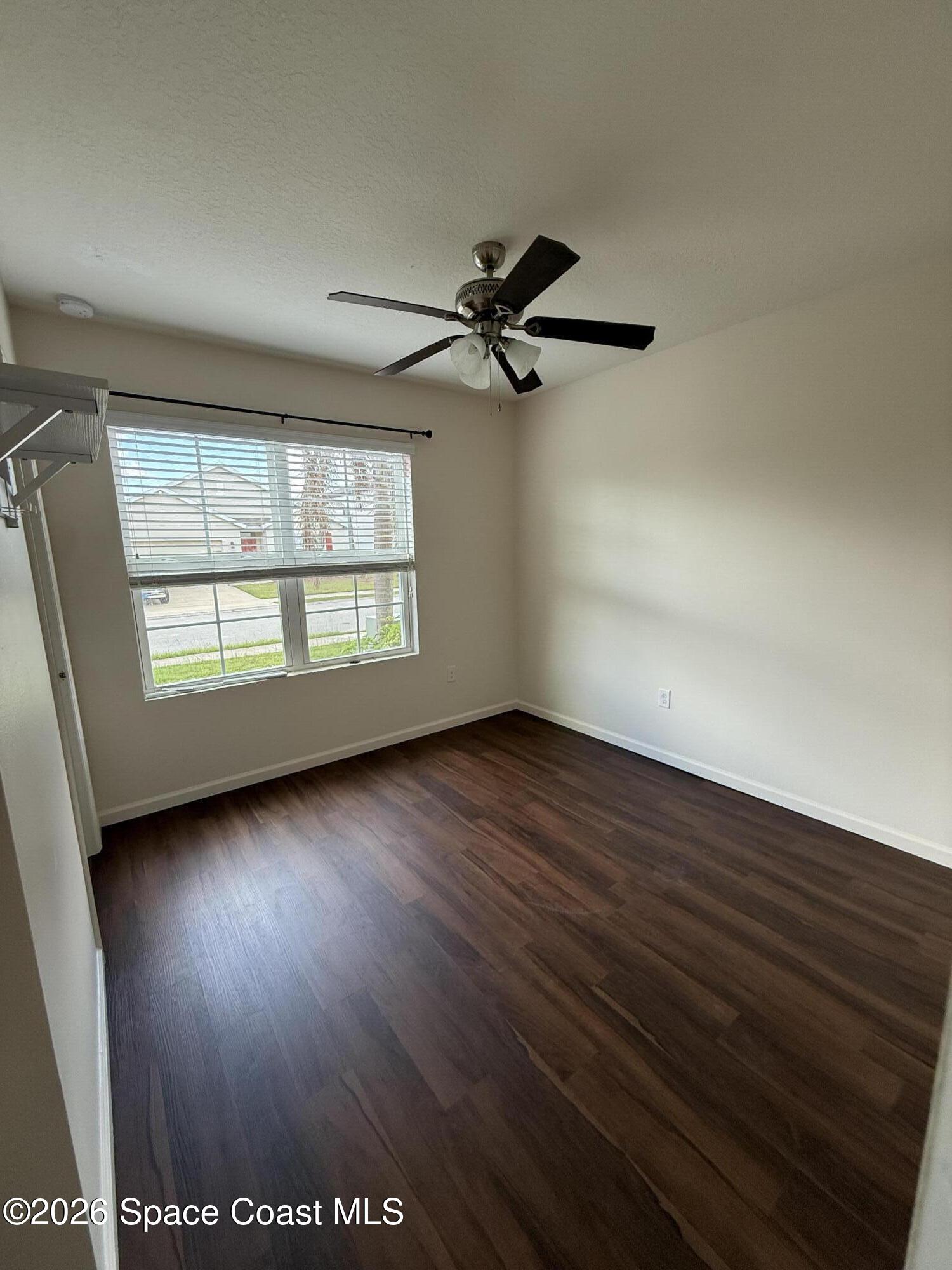 1070 Swiss Pointe Lane Rockledge, FL 32955 - Photo 4 of 18 an empty room with wooden floor fan and windows