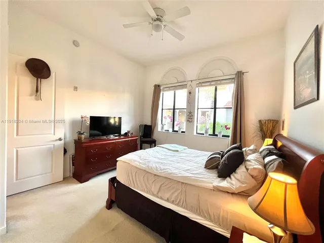 a bedroom with a bed and a flat tv screen on dresser