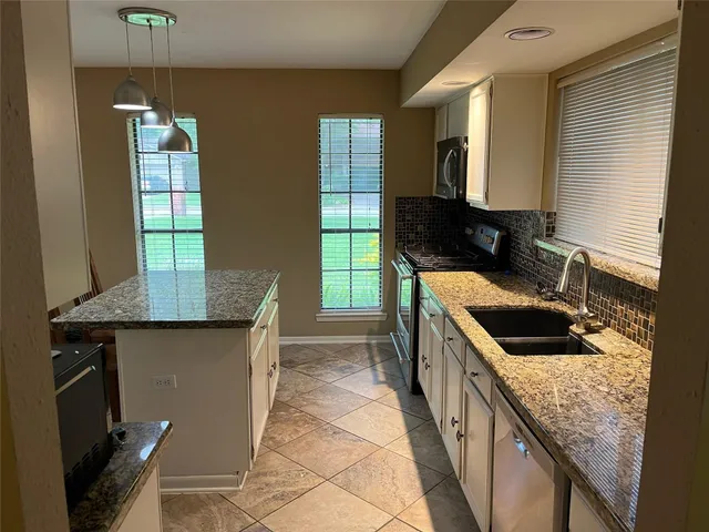 a kitchen with granite countertop a sink and a stove