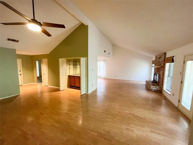 a view of an empty room with a fireplace and a window