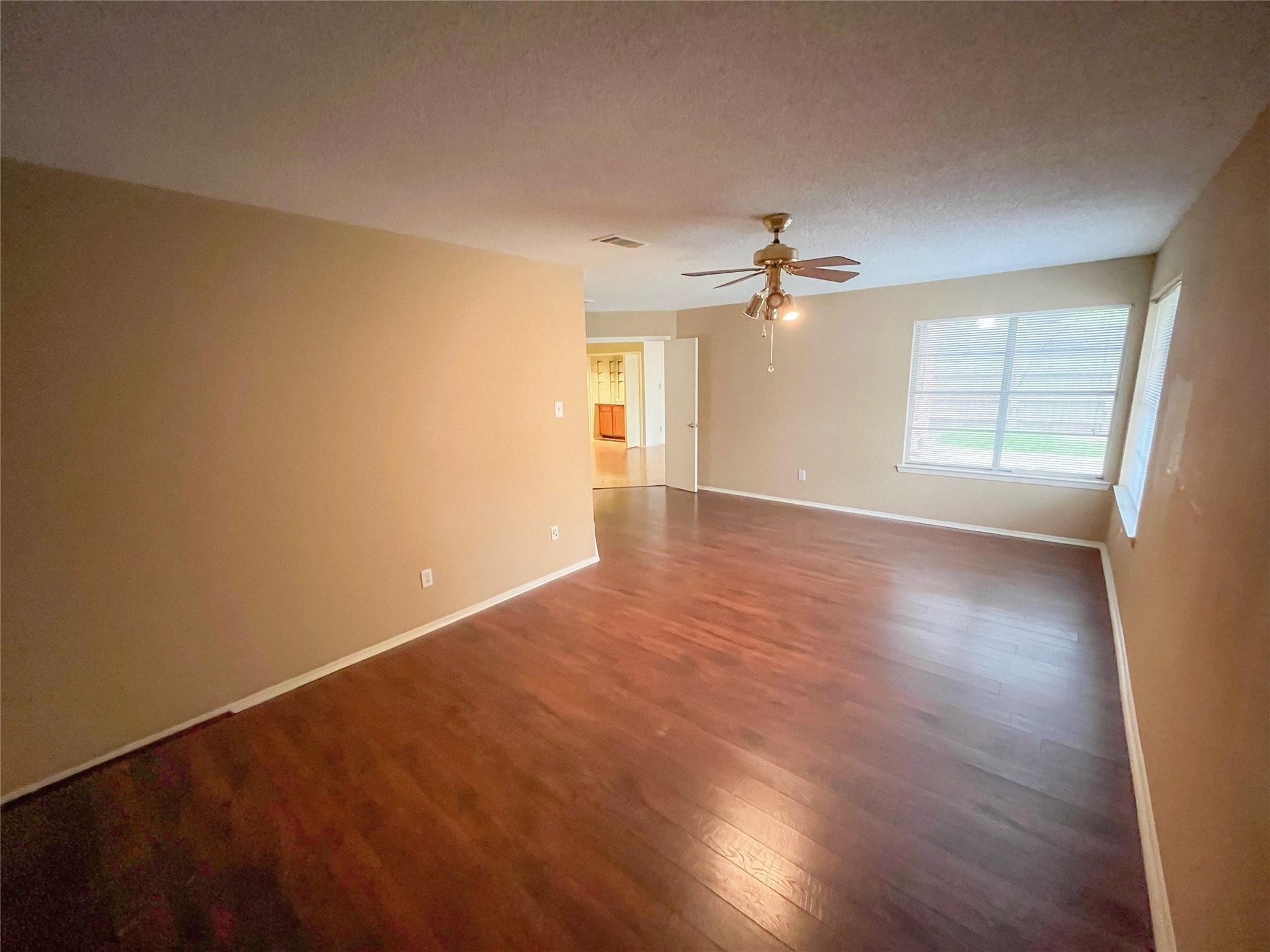 25531 Chapel Ridge Lane Spring, TX 77373 - Photo 10 of 14 an empty room with wooden floor chandelier fan and windows