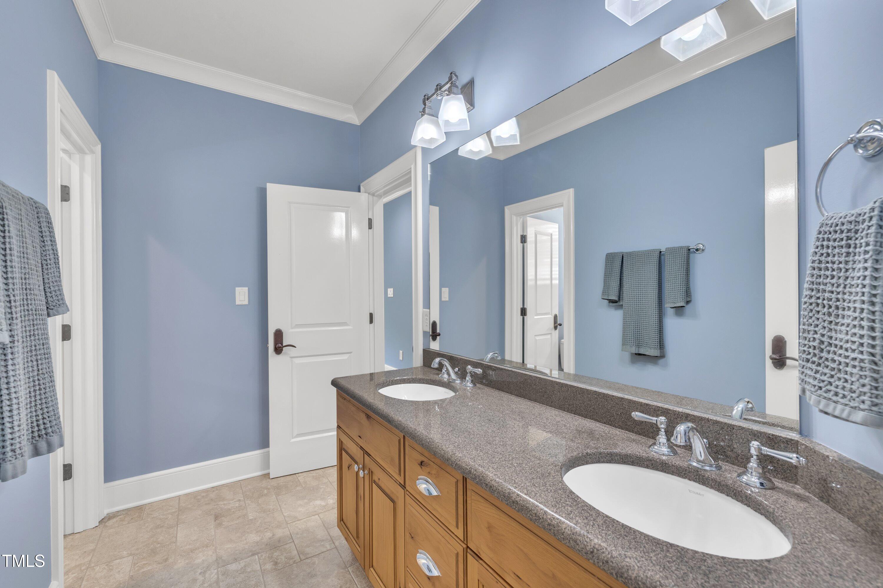 1112 Stone Kirk Drive Raleigh, NC 27614 - Photo 57 of 100 a bathroom with a granite countertop sink a light fixture and a mirror
