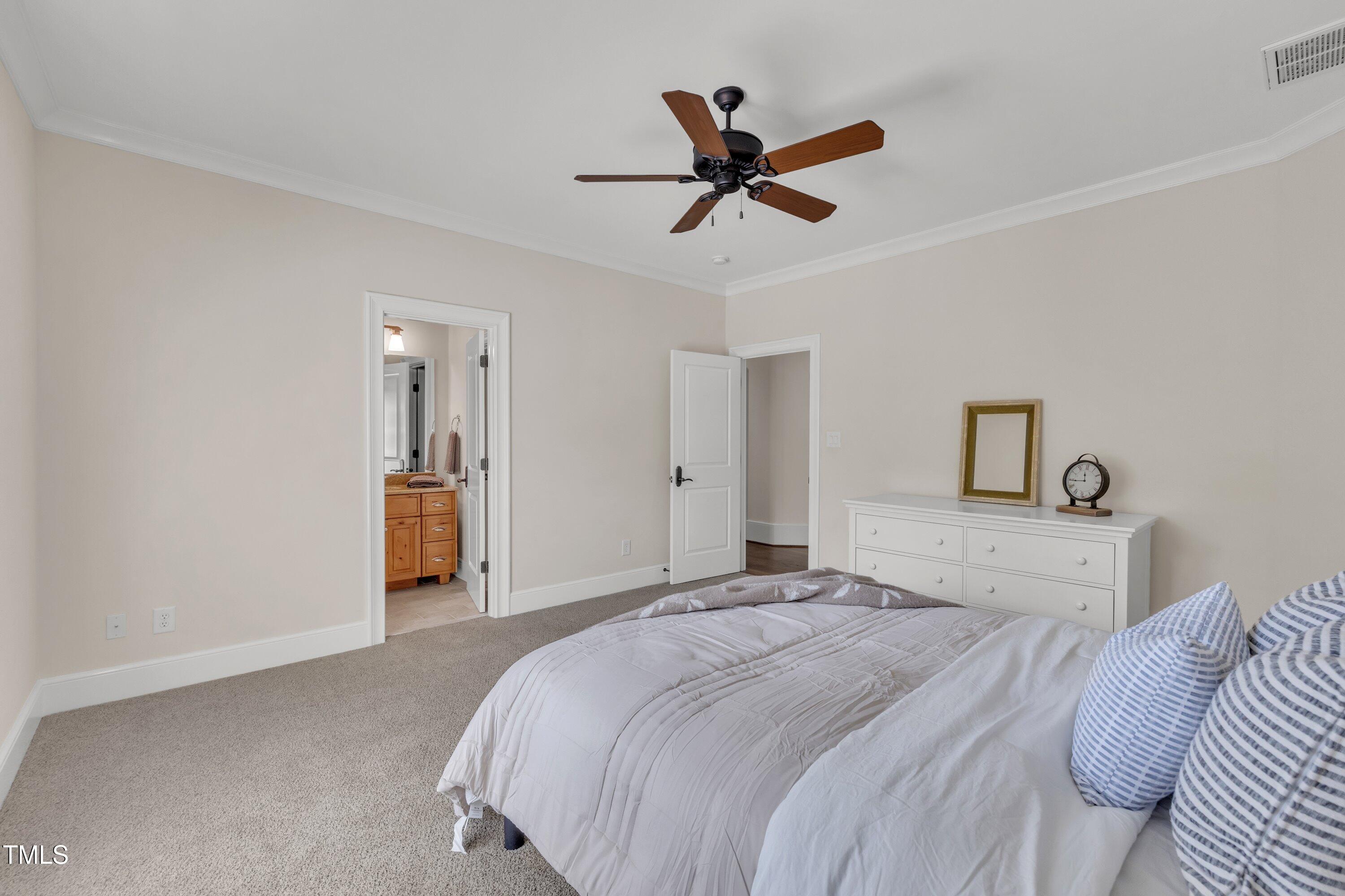 1112 Stone Kirk Drive Raleigh, NC 27614 - Photo 68 of 100 a bedroom with a large bed and a chandelier