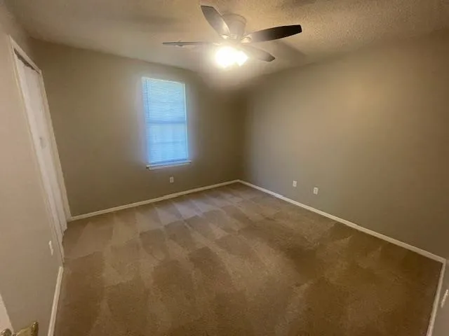 an empty room with chandelier fan